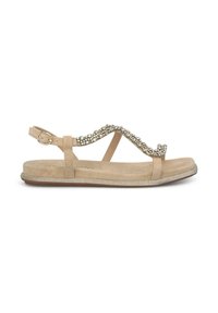 Sandalia beige con suela plana, que presenta una onda decorativa de piedras preciosas transparentes en la correa y una hebilla ajustable en el tobillo.
