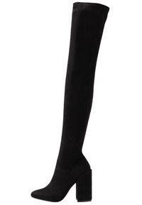 Botas negras por encima de la rodilla hechas de suave ante, con puntera afilada y un tacón grueso y alto. Textura suave sin patrones visibles.