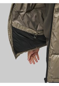 Puhvjakki sisemus on helepruun satiinitaoline vooder, musta võrkpocketiga, millel on reguleeritav tõmblöök.