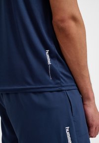 Marine sportshirt in een gladde, ademende stof. Voorzien van een nauwsluitend ontwerp met een subtiele merkenlogo en prestatieaccent.