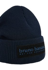 Donkerblauwe geribbelde gebreide beanie met een omgeslagen rand. Bevat een rechthoekig zwart label met blauwe tekst waarop "bruno banani NOT FOR EVERYBODY" staat.