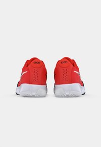 Røde atletiske sko med mesh-materiale, en afrundet form, hvide såler og sorte accenter med perforeringer ved hælen. Modelnummer 001 synligt.