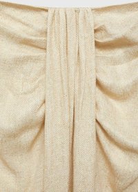Beige geweven stof met een subtiel visgraatpatroon, met zachte drapering en plooien voor extra textuur en diepte.