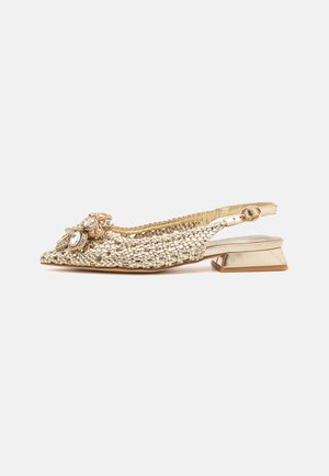 Zapato slingback dorado tejido con un bajo tacón cuadrado, adornado con un embellecimiento decorativo que presenta cristales y acentos de tela.