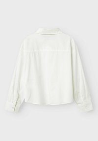 Witte lange mouw shirt met een kraag, gebogen zoom en knoopmanchetten. De stof lijkt glad met subtiele textuurdetails.