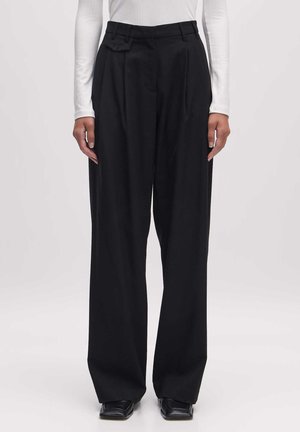 Zwarte geplooide broek met een hoge taille, gemaakt van een soepele stof. Beschikt over een schuine zak en een ontspannen, brede pasvorm.