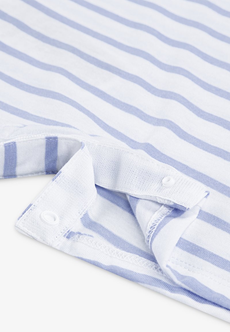 Nahaufnahme eines weißen Stoffes mit hellblauen Streifen und Druckknopfverschluss am Rand eines Kleidungsstücks.