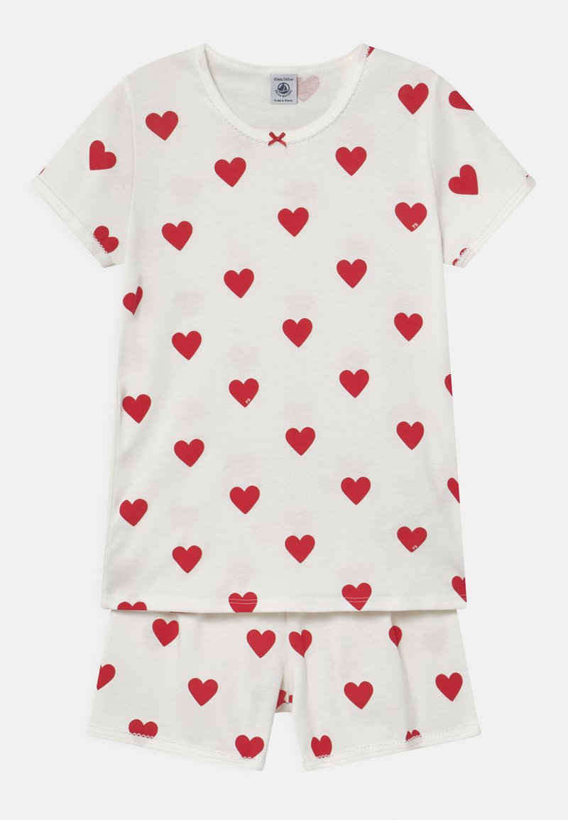 Complete set di pigiama a due pezzi composto da una maglietta bianca a maniche corte e pantaloncini abbinati, entrambi decorati con motivi a cuore rossi su un tessuto morbido.