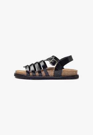 Sandalia de cuero negro con múltiples correas, plantilla de corcho, suela de goma negra y un hebilla de oro ajustable en el lateral.