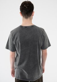 Dark gray cotton T-shirt with a crew neckline, short sleeves, and a relaxed fit, featuring a faded texture and casual design.