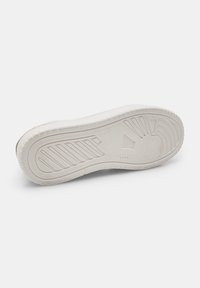 White sneaker outsole with textured rubber, featuring horizontal grooves and circular patterns. Simple and smooth design, rounded edges.