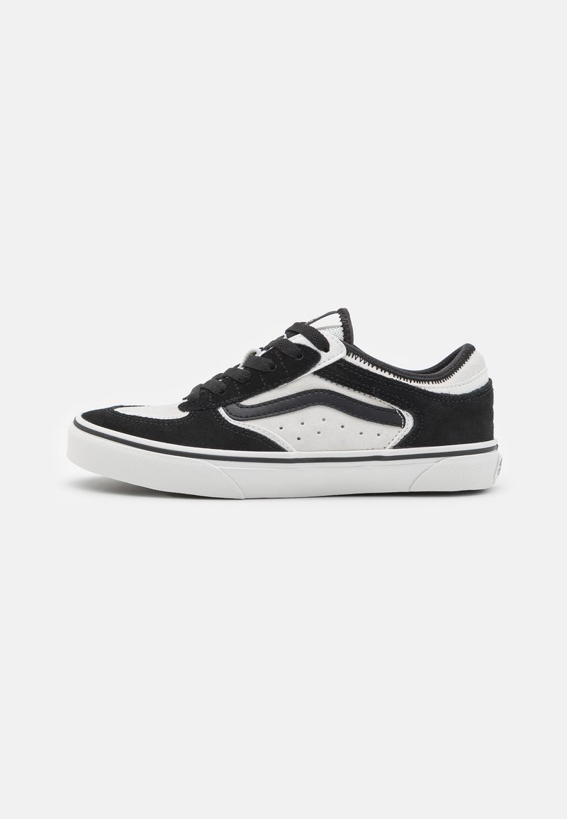 Zapatillas en blanco y negro con parte superior de ante, diseño clásico de skate, acentos perforados y suela de goma blanca con ribete negro.