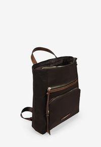 Mochila de nylon marrón con acentos de cuero, que cuenta con un cierre superior con cremallera y un bolsillo frontal con cremallera, forma rectangular y correas ajustables.