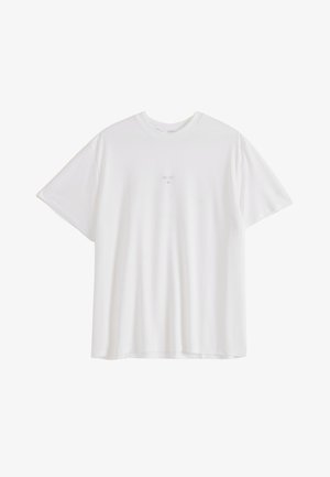 Camiseta blanca de manga corta con cuello redondo, con un pequeño y sutil logo o texto en el centro del pecho, lisa y holgada.