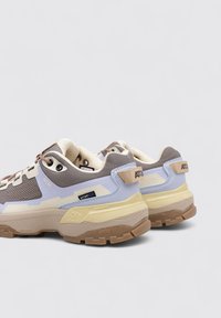 Baskets de sport avec une tige en mesh texturé marron et bleu clair, accents gris, semelle intermédiaire jaune et semelle extérieure en caoutchouc marron.