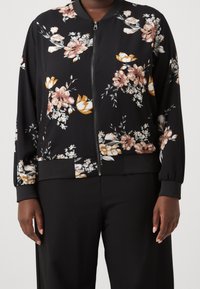 Černá bomber bunda s květinovým potiskem v odstínech růžové a žluté, s předním zipem, žebrovanými manžetami a lemem. Texturovaná látka.