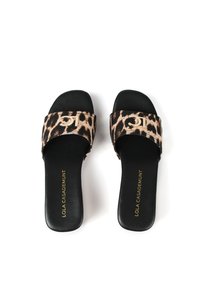 Sandalias de slide con estampado animal y suela negra. Cuenta con una correa ancha con un acento del logo en dorado y una textura suave. Nombre de la marca impreso por dentro.