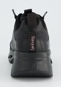 Black sneaker featuring a smooth synthetic upper, textured heel, and fabric accents. A prominent logo is displayed near the heel tab.