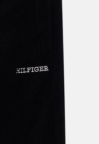 Tommy Hilfiger POLAR UNISEX - Tracksuit bottoms - desert sky