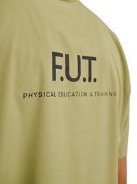 Koszulka oliwkowa z czarnym napisem "F.U.T." nad mniejszym napisem "WYCHOWANIE FIZYCZNE I TRENING" na plecach.
