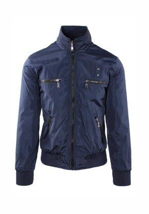 Giacca blu navy con cerniera, collo alto, due tasche con cerniera sul petto, due tasche laterali con cerniera e polsini e orlo a coste.