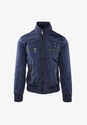 Giacca blu navy con cerniera, collo alto, due tasche con cerniera sul petto, due tasche laterali con cerniera e polsini e orlo a coste.