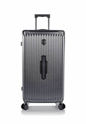 Valise à coque dure gris foncé avec des rainures verticales, quatre roulettes pivotantes, une poignée télescopique et une poignée supérieure encastrée.