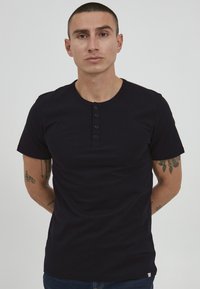 Black short-sleeve t-shirt featuring a round neckline and five-button placket. Smooth texture with a fitted design and minimal branding.