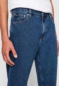 Blå denimjeans med en klassisk rak passform, subtila sömmar och CK-logotyp på framfickan, med en mjuk textur.