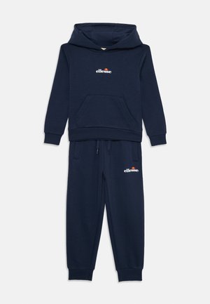 Setti navy blue -huppari ja -housut, jotka on valmistettu pehmeästä puuvillasekoitteesta. Setissä on etutasku, ribbaus hihansuissa ja pieni logo korostaa molempia vaatekappaleita.