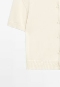 Cardigan en tricot à manches courtes couleur crème avec ourlet côtelé et boutons assortis sur le devant.