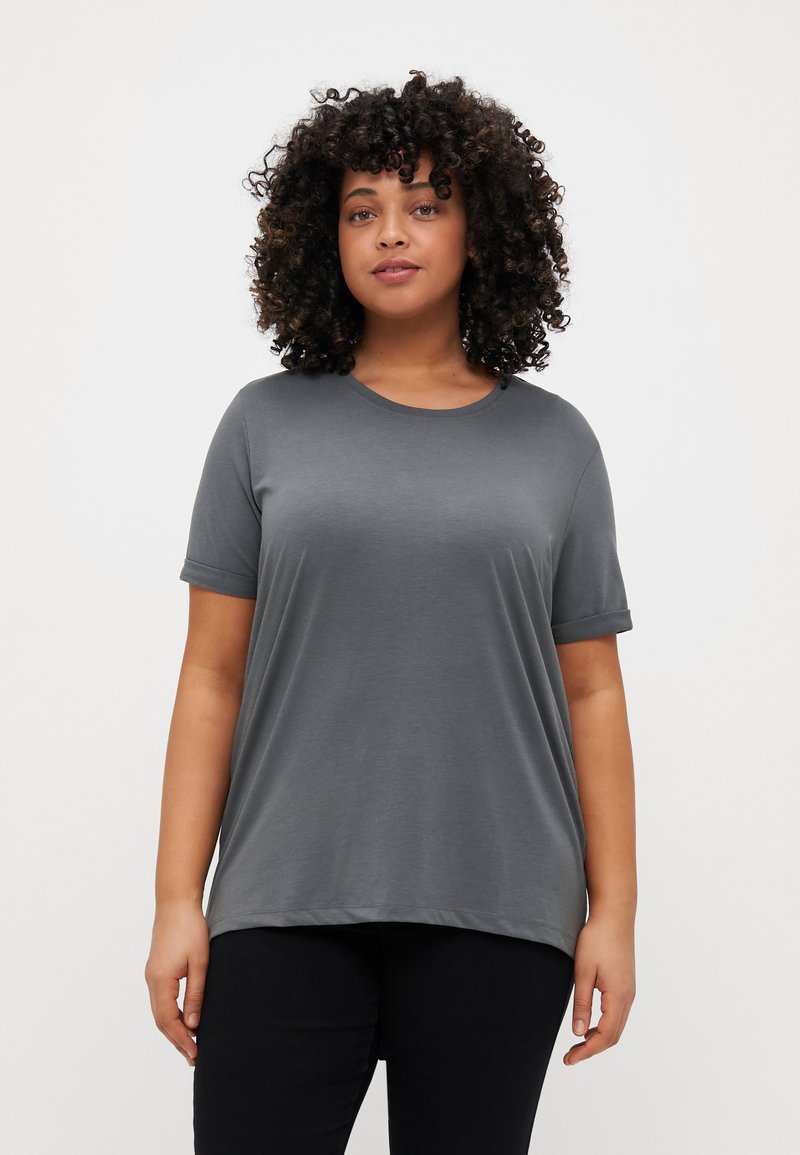 Gray short-sleeve T-shirt with a round neckline, soft fabric, relaxed fit, and rolled cuffs, paired with dark trousers.