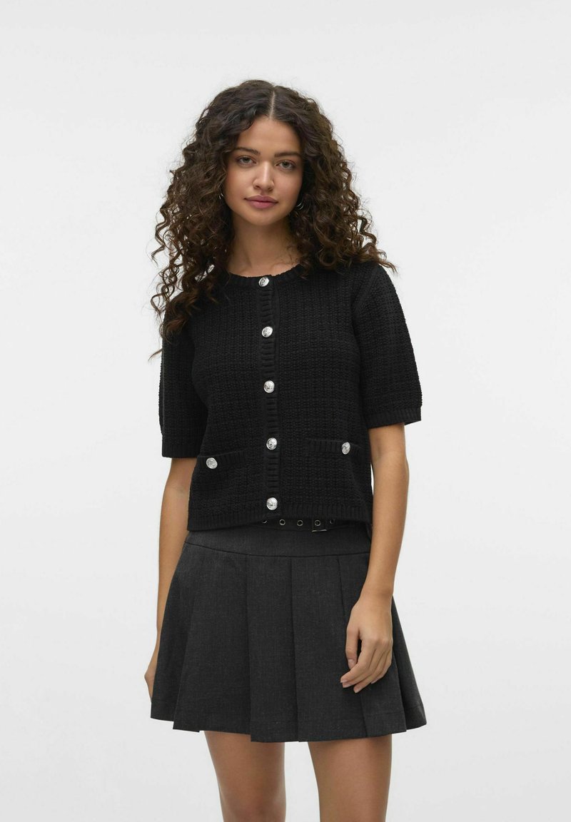 Zwarte cardigan met korte mouwen van een getextureerde brei-stof, met ronde zilveren knopen, twee voorzakken en een ontspannen pasvorm.