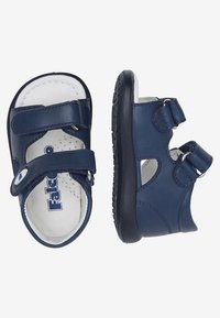 Sandales en cuir bleu marine avec deux brides réglables, semelle intérieure perforée et semelle en caoutchouc. Logo présent sur la semelle intérieure.