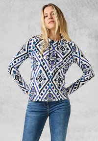 Wit lange mouwen hoodie met blauwe, zwarte en paarse geometrische patronen; voorzien van een trekkoordkap en een getailleerde uitstraling.