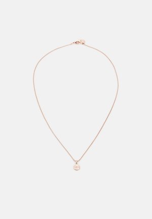 Delicado collar de cadena de oro rosa con pequeño colgante redondo grabado con la letra T, colocado plano sobre un fondo blanco.