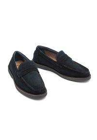Loaferi negri din suede, cu o textură netedă, având un design clasic de mocasin, un vârf rotund și o talpă din cauciuc maro în contrast.