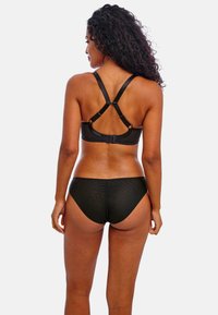 Black bikini set featuring a sports bra-style top with crisscross straps and textured low-rise bottoms. Made from smooth, stretchy fabric.