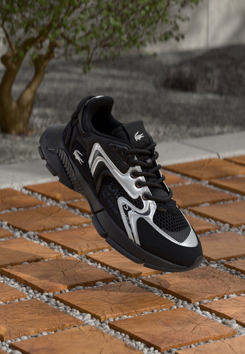 Baskets athlétiques noires et argentées avec des détails en mesh et logo, flottant au-dessus de carreaux en bois carrés en extérieur.