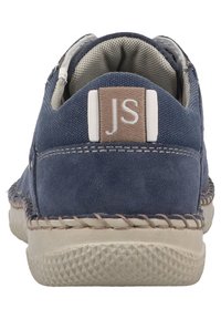 Blaues Wildleder-Casual-Schuh mit beigen Akzenten, runder Zehenform, weißem Logopatch an der Ferse und strukturiertem Gummisohle mit Nahtdetails am Rand.