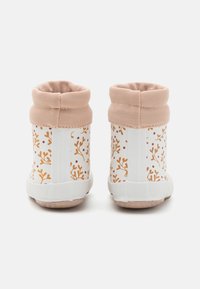 Bottes de pluie pour enfants à base blanche avec un motif floral orange, dotées de colliers rembourrés rose clair, vues de dos sur fond blanc.