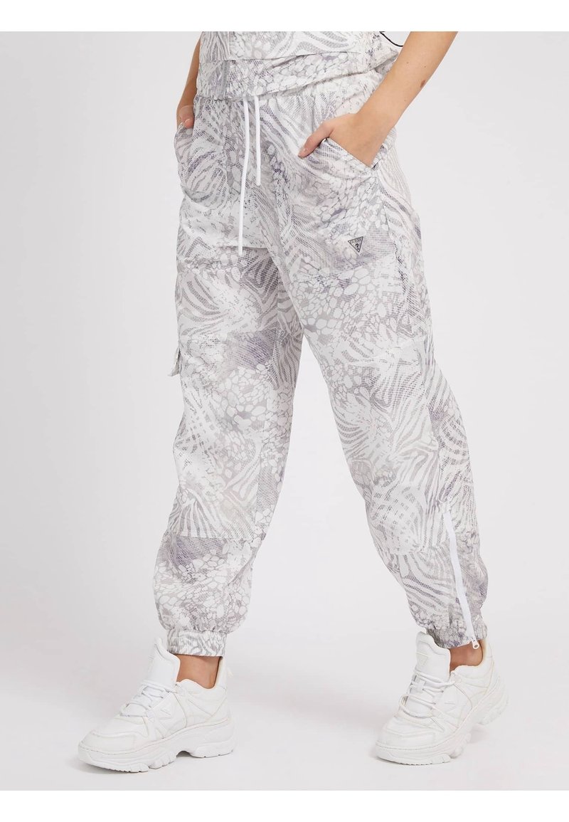 Jogging léger à motif gris avec des poignets élastiques, deux poches latérales et une taille à cordon. Associé à des baskets blanches.