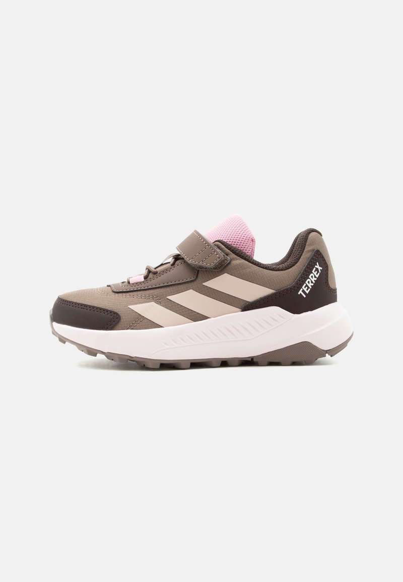 Καφέ και ροζ αθλητικό παπούτσι Adidas Terrex με ιμάντα με βέλκρο, τρεις μπεζ ρίγες και παχύ λευκό πάτο, σχεδιασμένο για εξωτερική χρήση.