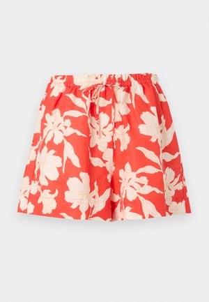 Røde shorts med elastisk midje, hvit blomsterprint og snøring foran, vist mot en enkel lys bakgrunn.