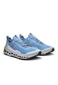 Light blue athletic shoes with a textured mesh upper, white midsole, black rubber outsole, and distinctive side cutouts for breathability.