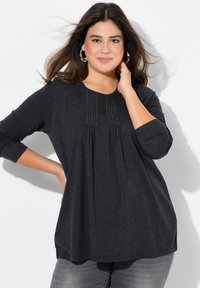 Dunkelgraues Langarmshirt mit rundem Halsausschnitt, ausgestattet mit Falten und dekorativen Nähten am Oberteil. Weicher Stoff und lässige Passform.