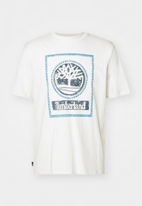 White cotton t-shirt featuring a blue Timberland logo centered within a rectangular border. Short sleeves and crew neckline.