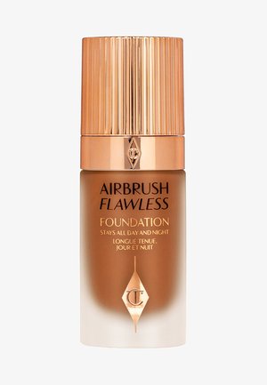 Airbrush Flawless Foundation in a cylindrical glass bottle. Features a gold ribbed cap, gradient amber to white finish, and embossed logo.