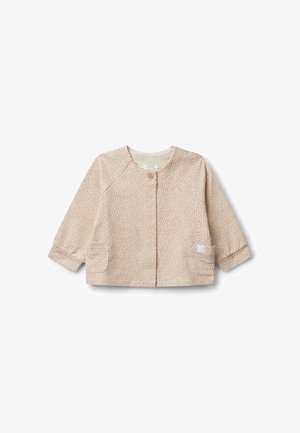 Veste beige clair avec de petits points marron, dotée d'un col rond, d'une fermeture à boutons et de deux poches avant. Tissu doux avec des manches longues.