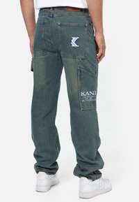 Jeanscargo i bleknad blå med flera fickor, med en KANJI-logotyp patch och sydda detaljer. Avslutade med en avslappnad passform.